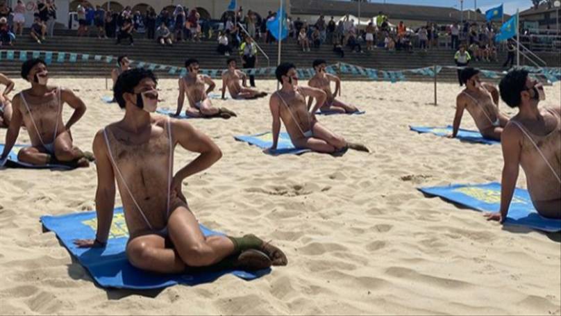 Forty Men In ‘Maskinis’ Crash Bondi Beach In Borat 2 Stunt
