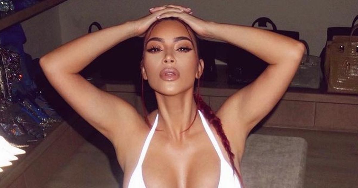 Kim Kardashian is fire in tiny white bikini as she poses among her handbags